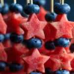 Easy Patriotic Fruit Kabob Skewers arranged on white plate